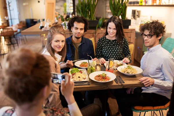 Друзья со смартфоном фотографируются в ресторане — стоковое фото