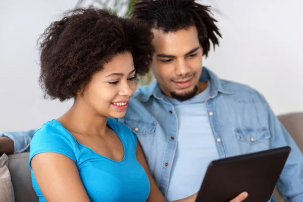 Sorrindo casal feliz com tablet pc em casa — Fotografia de Stock