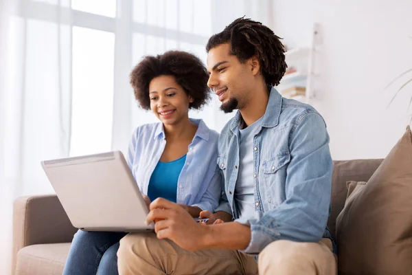 Sonriente feliz pareja con portátil en casa —  Fotos de Stock