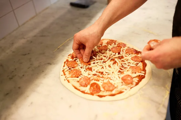 Pizza pizza, salam ekleyerek el yemek — Stok fotoğraf