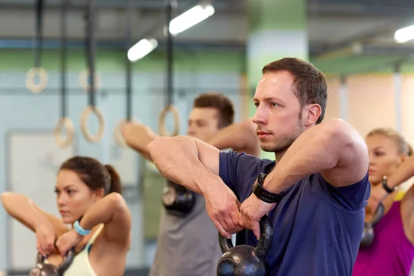 Skupina lidí s kettlebells, cvičení v tělocvičně — Stock fotografie