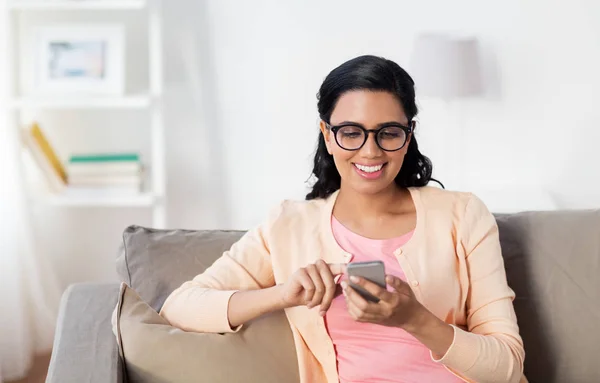 Щаслива жінка смс повідомлення на смартфоні вдома — стокове фото