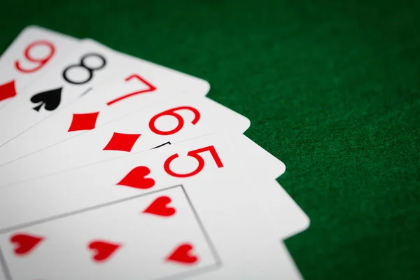 Main de poker de cartes à jouer sur tissu de casino vert — Photo