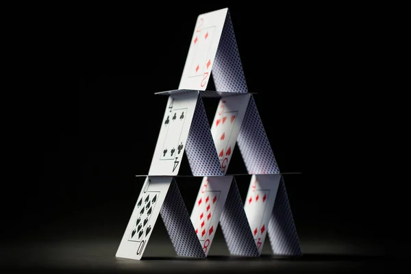 Casa de jogar cartas sobre fundo preto — Fotografia de Stock