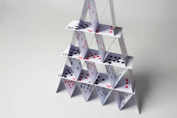 Дом игральных карт на белом фоне — стоковое фото