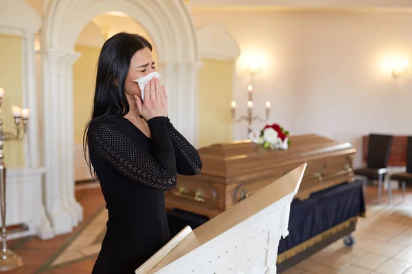 Mujer llorando cerca de ataúd en el funeral en la iglesia —  Fotos de Stock