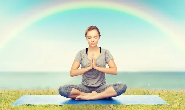 Kobieta co jogi medytacji w lotosu stanowią na mat — Zdjęcie stockowe