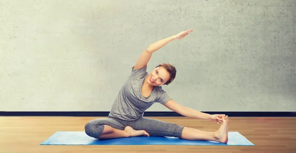Glückliche Frau macht Yoga und Stretching auf Matte — Stockfoto