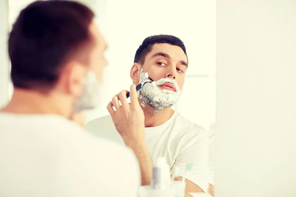Чоловік голить бороду з лезом бритви у ванній — стокове фото