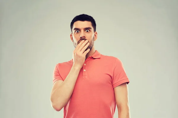 Hombre asustado en polo camiseta sobre fondo gris — Foto de Stock