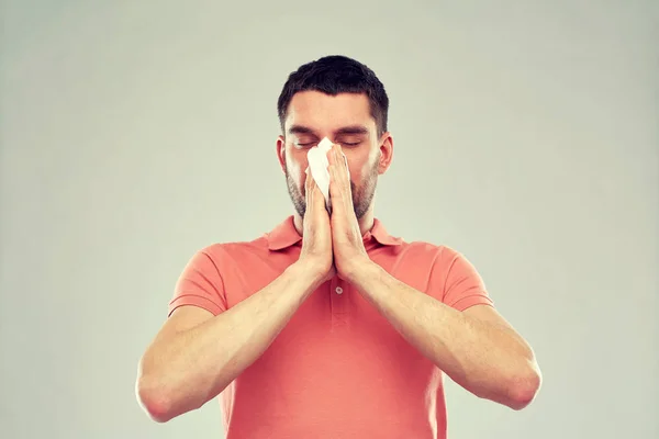 Homem doente com papel guardanapo soprando nariz — Fotografia de Stock