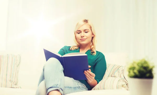 Lächelnde Frau liest Buch zu Hause — Stockfoto