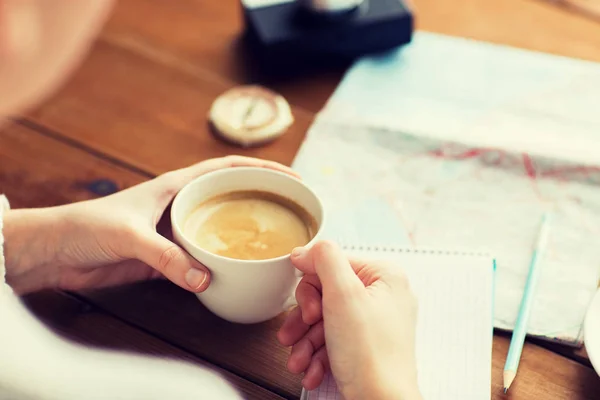 Primer plano de las manos con taza de café y cosas de viaje — Foto de Stock