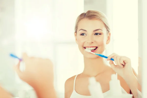 Donna con spazzolino da denti pulizia dei denti in bagno — Foto Stock