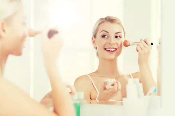 Femme avec brosse de maquillage et poudre à la salle de bain — Photo