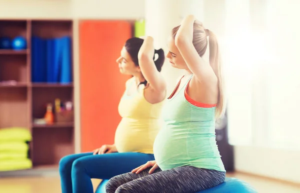 Femmes enceintes heureux faisant de l'exercice sur fitball dans la salle de gym — Photo