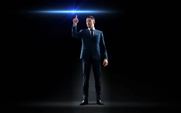 Бизнесмен в костюме указывает пальцем на лазерный свет — стоковое фото
