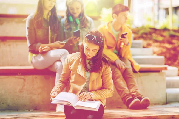 High school student tjej läser bok utomhus — Stockfoto