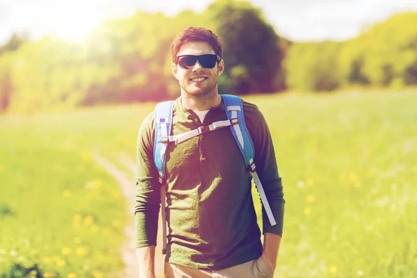 Glad ung man med ryggsäck vandring utomhus — Stockfoto