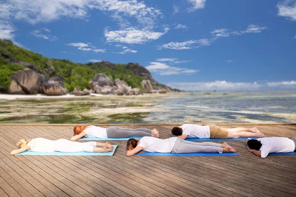 Gruppe von Menschen, die Yoga im Freien machen und lügen — Stockfoto