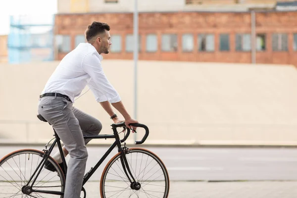 Hombre con auriculares a caballo bicicleta en la calle de la ciudad — Foto de Stock