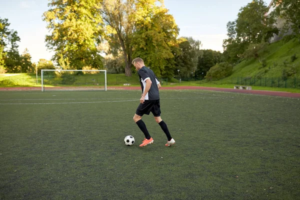 Fußballer spielt mit Ball auf Fußballplatz — Stockfoto