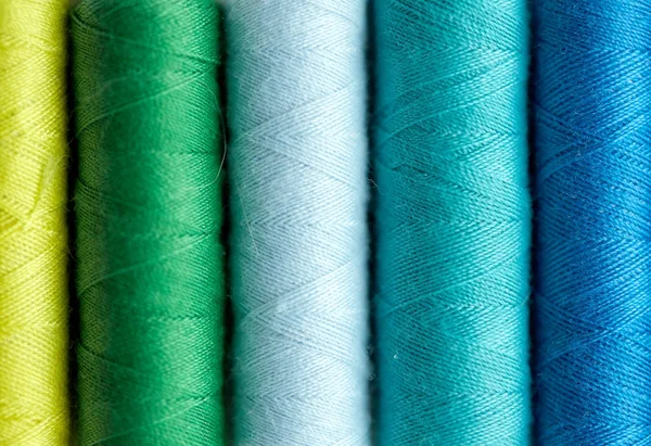 Rząd kolorowych szpul nici na stole — Zdjęcie stockowe