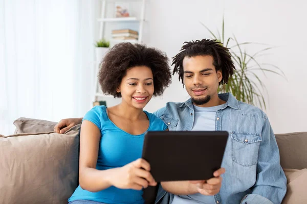 Sonriendo feliz pareja con la tableta PC en casa — Foto de Stock