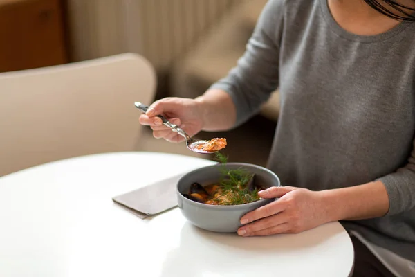 Vrouw eten van vissoep in café of restaurant — Stockfoto