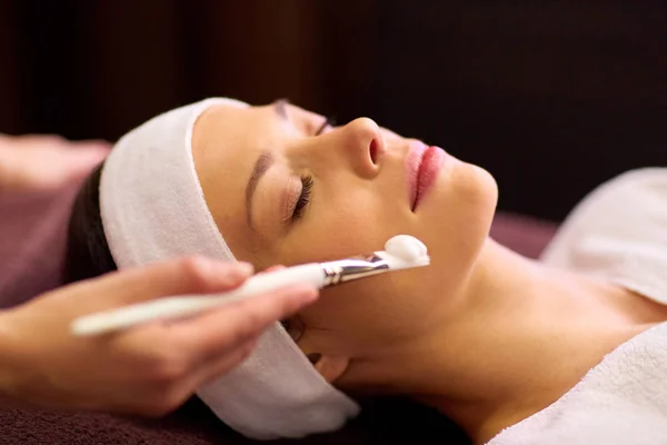 Esteticista aplicando mascarilla facial a mujer en spa —  Fotos de Stock