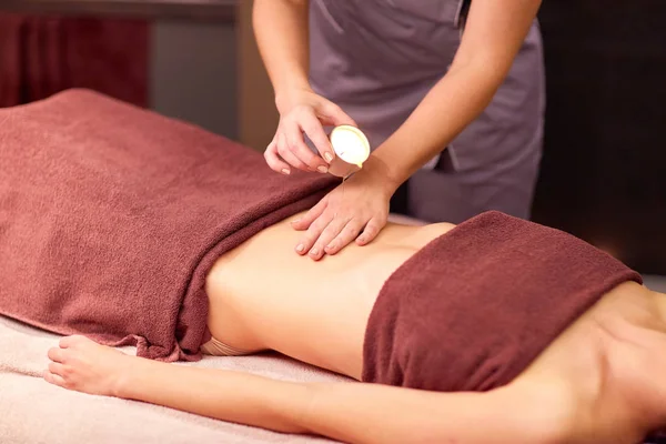 Mujer acostada y teniendo masaje con aceite caliente en el spa —  Fotos de Stock