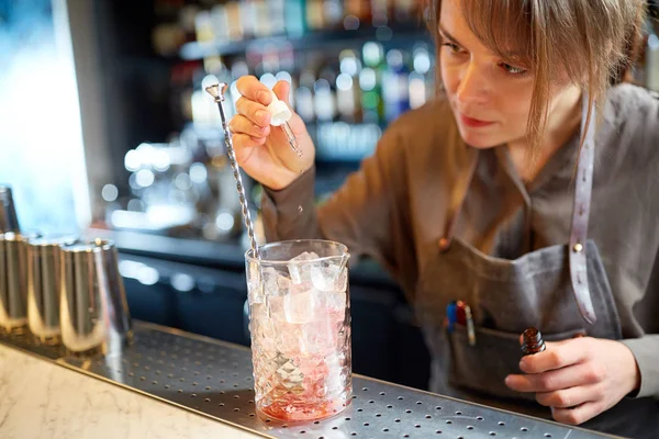 Barista aggiungendo essenza al bicchiere da cocktail al bar — Foto Stock