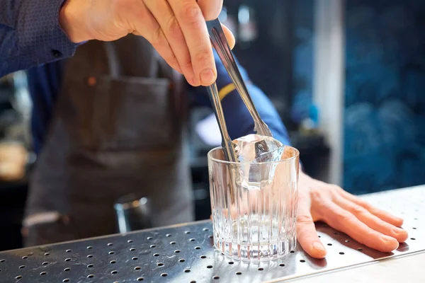 Barman ajoutant glaçon dans le verre au bar — Photo
