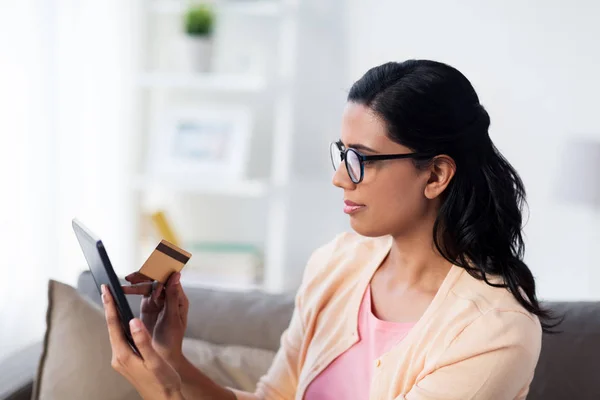 Mujer feliz con tablet PC y tarjeta de crédito en casa — Foto de Stock