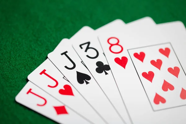 Mão de poker de jogar cartas no pano de casino verde — Fotografia de Stock