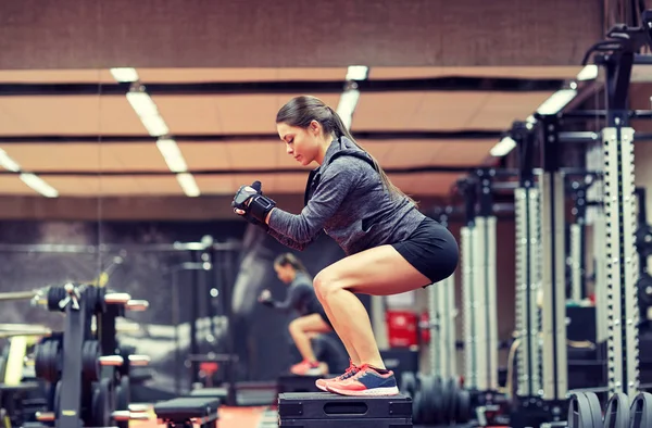 女人做蹲在平台上在健身房 — 图库照片