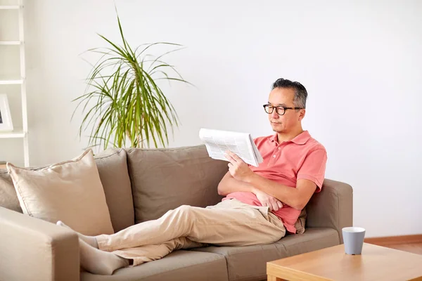 Ευτυχισμένος άνθρωπος σε γυαλιά ανάγνωσης εφημερίδων στο σπίτι — Φωτογραφία Αρχείου