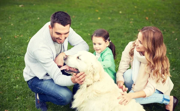 Happy family with labrador retriever dog in park — Stock Photo, Image