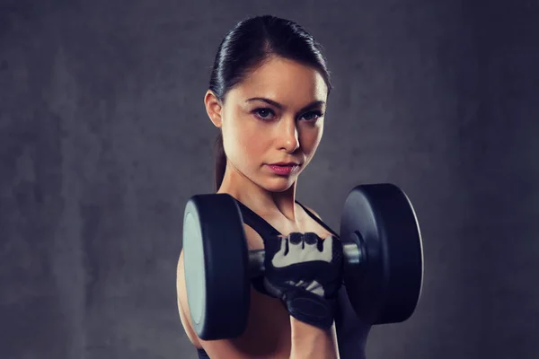 Jeune femme flexion muscles avec haltères dans la salle de gym — Photo
