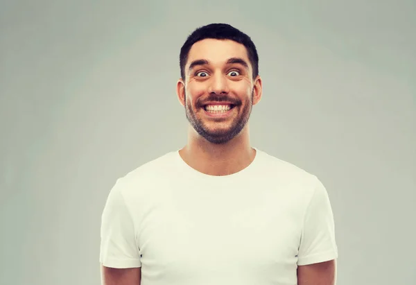 Uomo con faccia divertente su sfondo grigio — Foto Stock