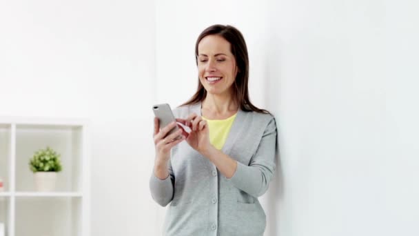 Happy woman texting message on smartphone at home — Stock Video