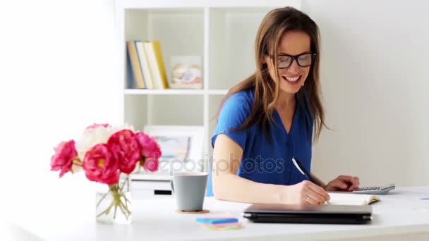 Femme avec calculatrice et ordinateur portable au bureau — Video