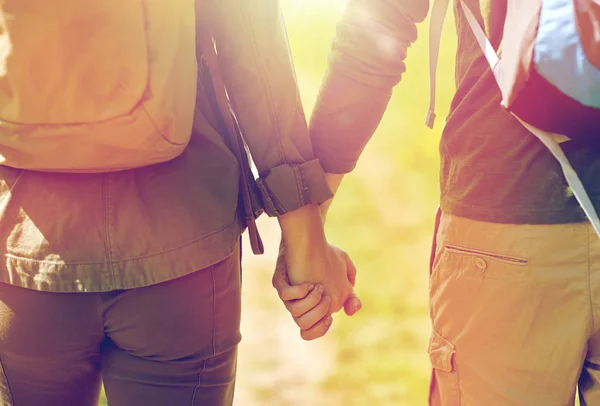 Close up of couple with backpacks holding hands — Stock Photo, Image