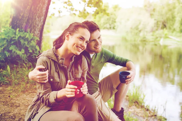 Lyckliga par med cups dricka i naturen — Stockfoto