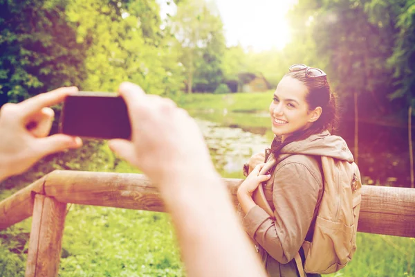 Couple with backpacks taking picture by smartphone — Stock Photo, Image