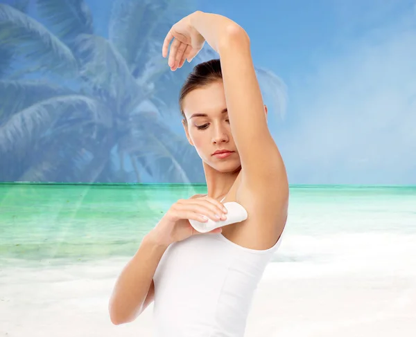 Mujer con desodorante antitranspirante sobre la playa —  Fotos de Stock