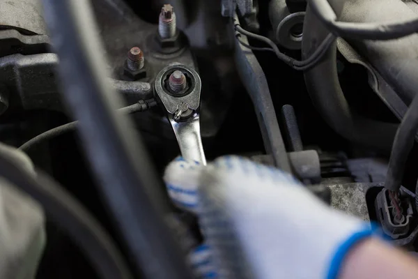Meccanico con chiave inglese che ripara auto in officina — Foto Stock