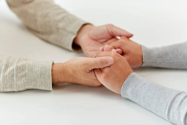 Närbild av gammal man och ung kvinna som håller händerna — Stockfoto