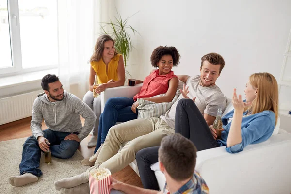 Gelukkige vrienden met popcorn en bier thuis — Stockfoto