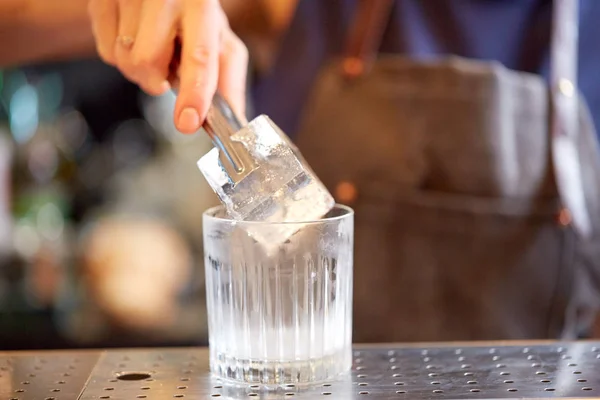 Barista aggiungendo cubetto di ghiaccio in vetro al bar — Foto Stock